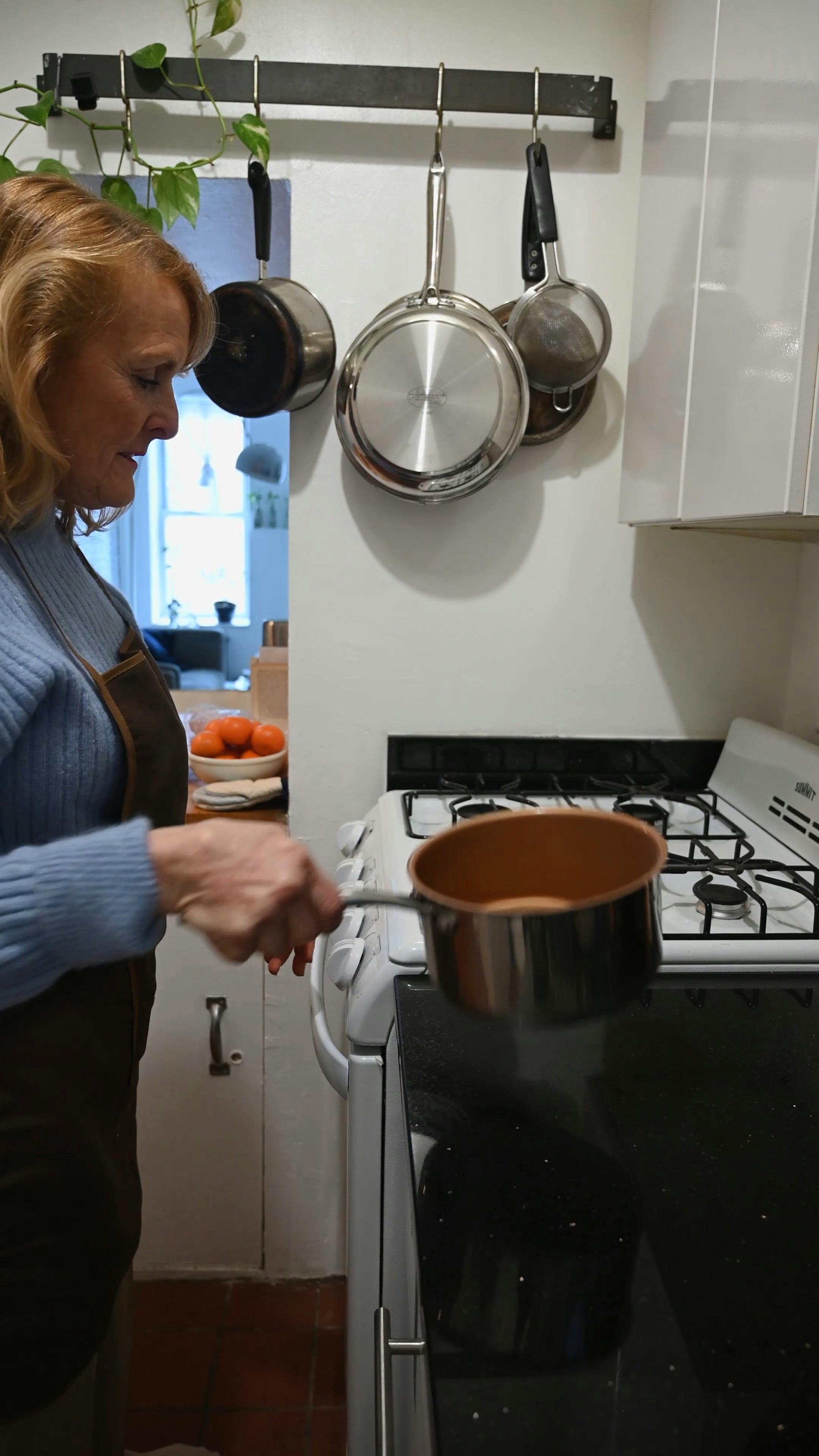 Elderly Woman Placing Saucepan on Stove · Free Stock Video