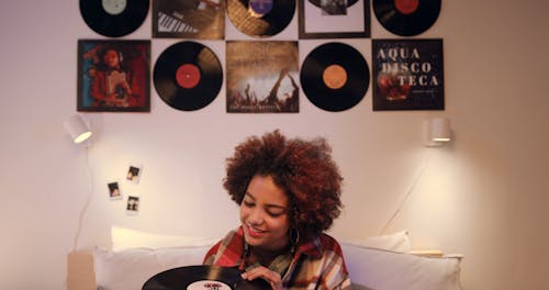 A Happy Woman Holding a Vinyl Record