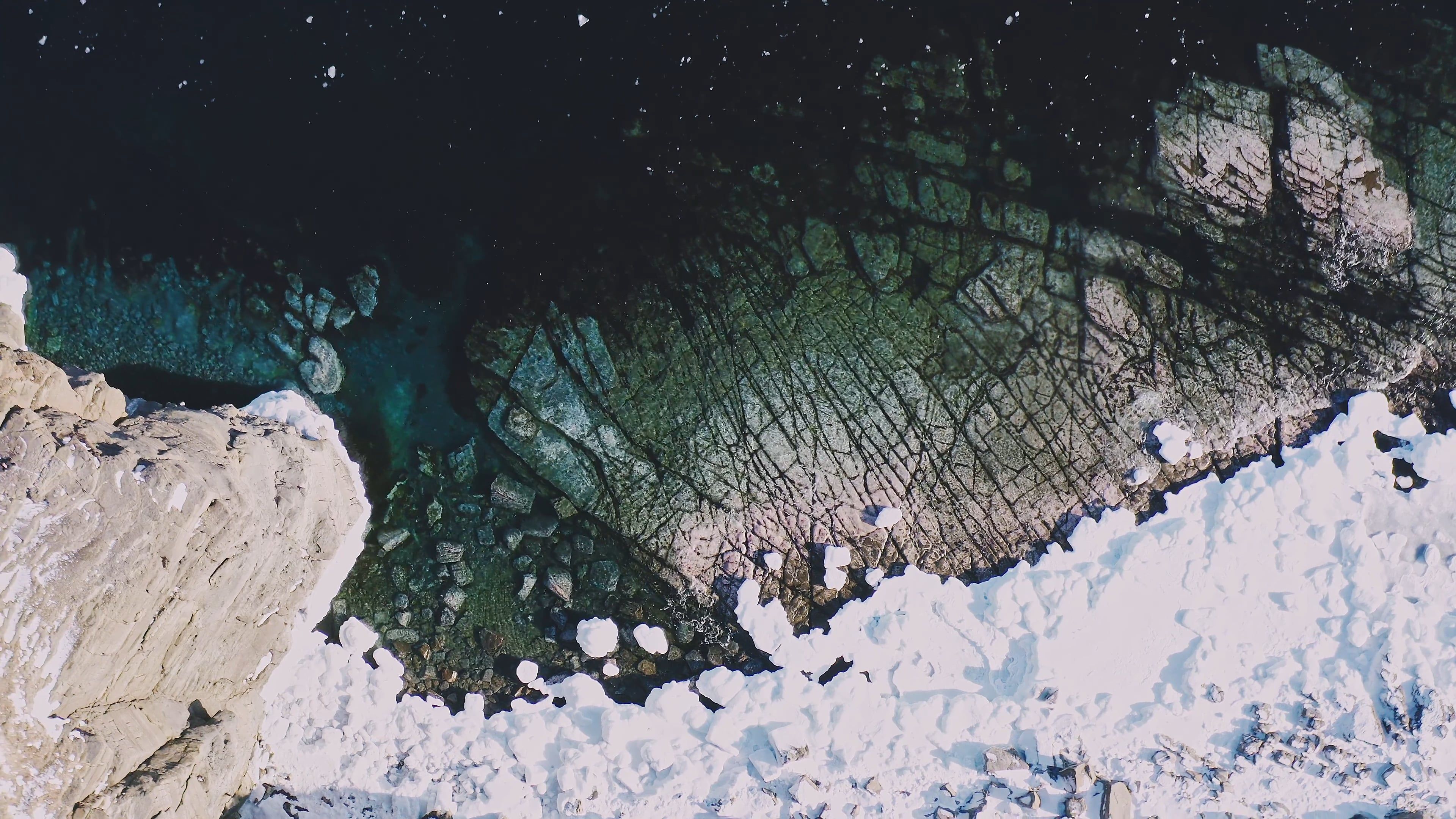 Drone Footage of a Snow Covered Cliff and an Icy Shoreline Free Stock ...
