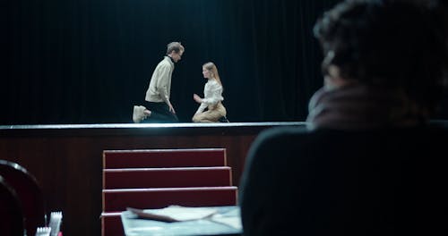 A Stage Play Director Supervising The Rehearsals