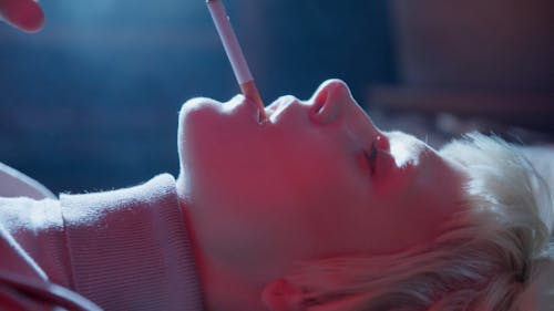 Close up of a Woman Smoking while Lying down on a Floor