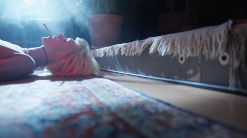 A Woman Smoking a Cigarette while Lying down on a Floor