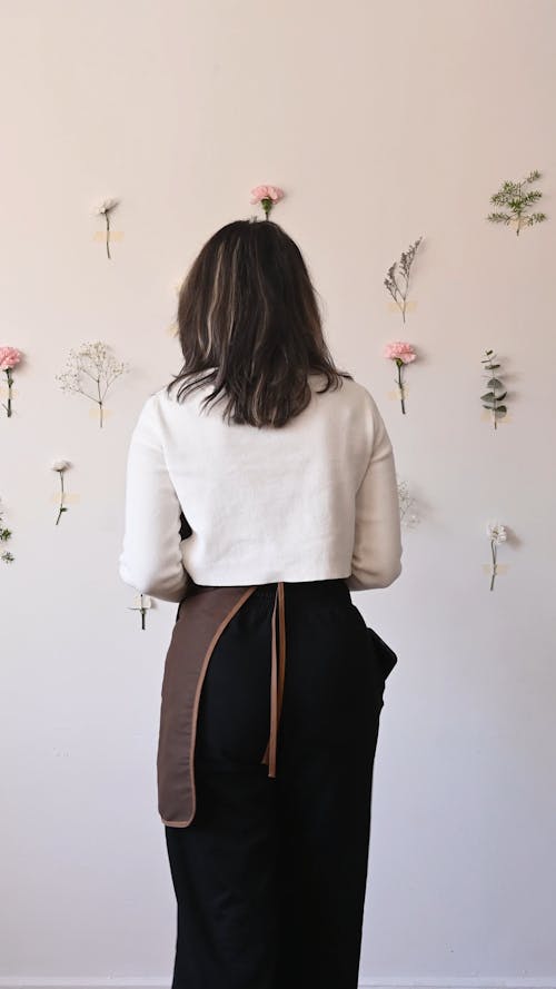 A Woman Putting Flowers on the Wall