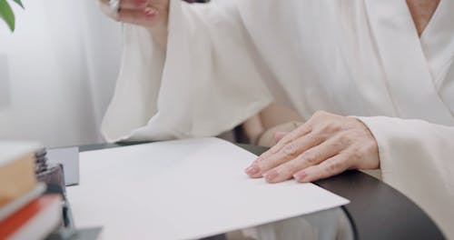 A Woman Using a Dip Pen while writing on a Piece of Paper