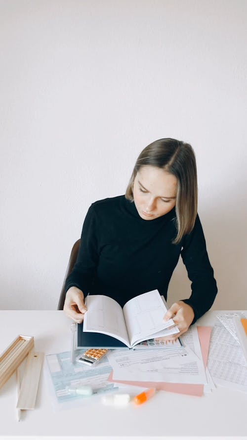 A Woman Scanning a Book and Documents