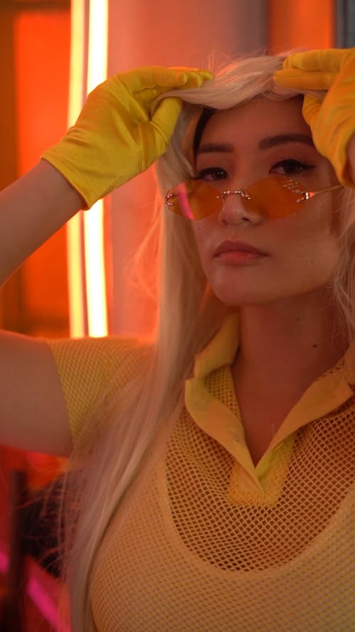 A Woman in a Yellow Outfit Fixing her Wig