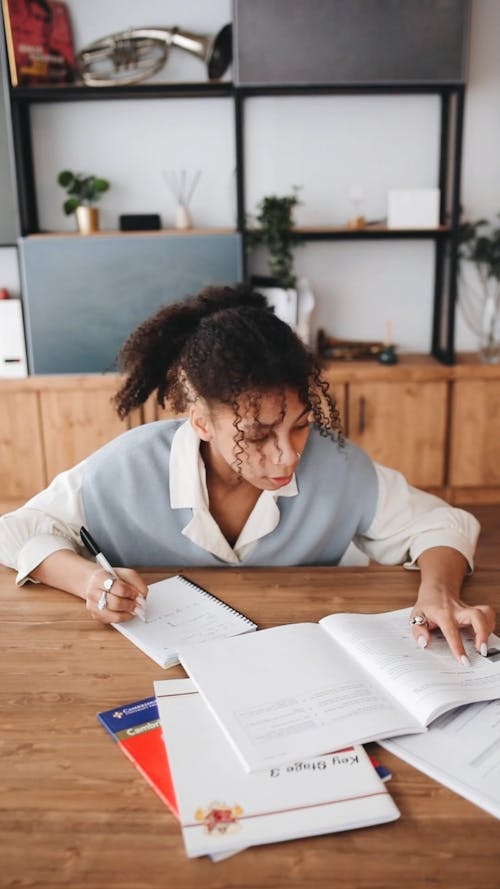 Student Studying and Writing Notes on Her Notebook