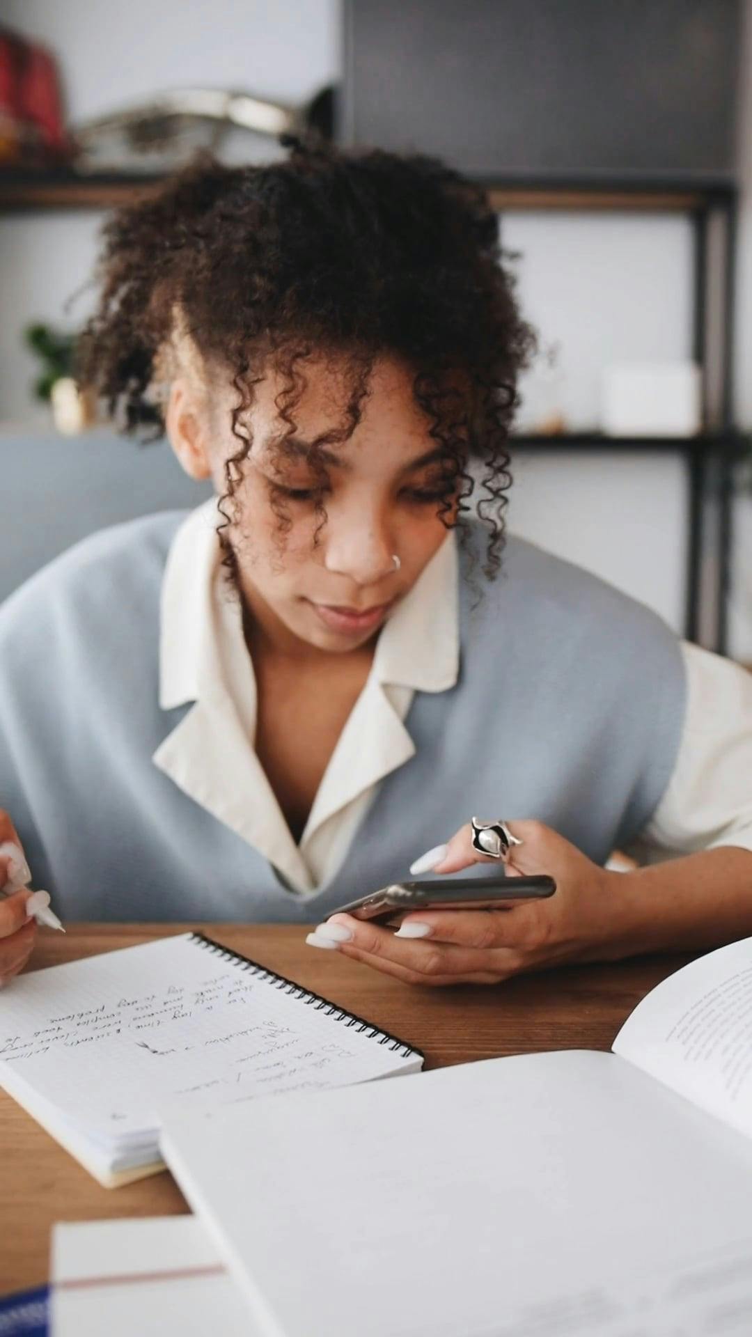 Student Looking at Her Smartphone While Studying · Free Stock Video