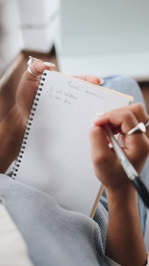 Person Writing on Her Notebook