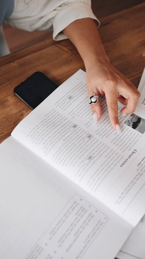 Close-Up View of a Person's Hand on a Book