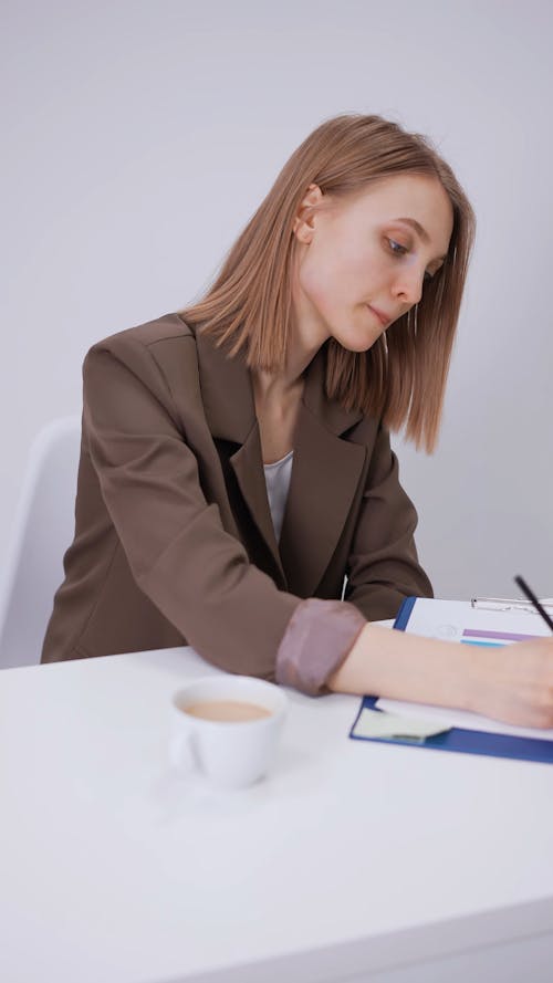 A Woman Working while Drinking Coffee