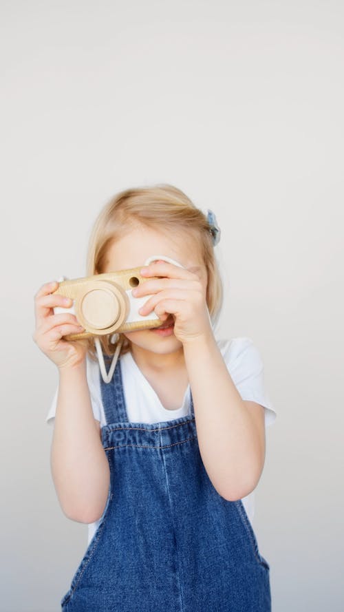 A Young Girl Playing With A Toy Camera