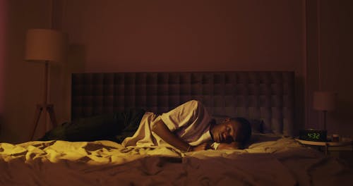 Man Lying Down on His Bed while Using His Smartphone