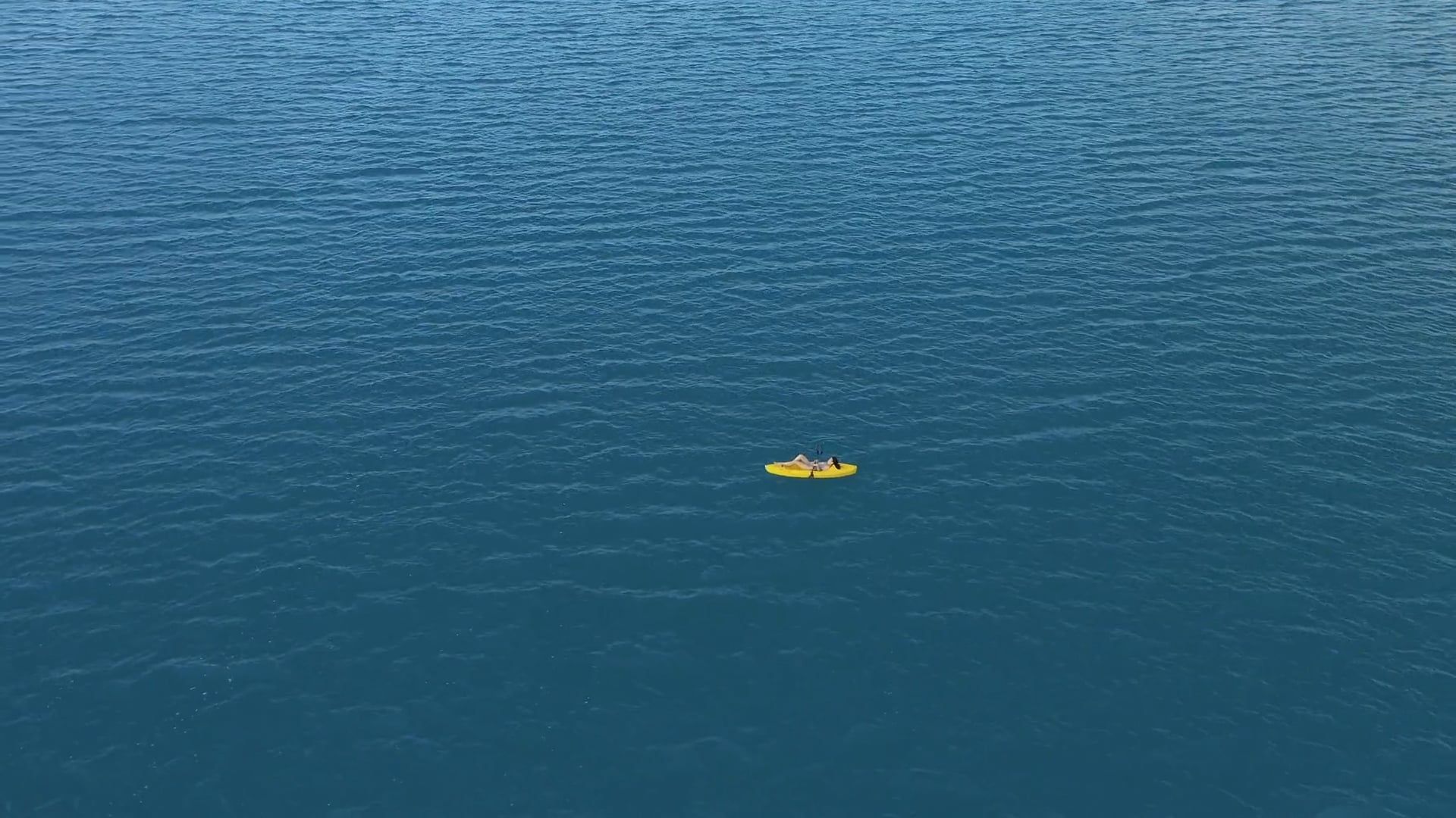 Aerial View of a Woman Lying in the Kayak in the Middle of the Ocean · Free Stock Video