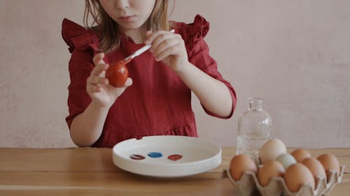 A Girl Painting an Easter Egg