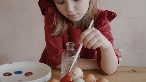 A Girl Painting an Easter Egg