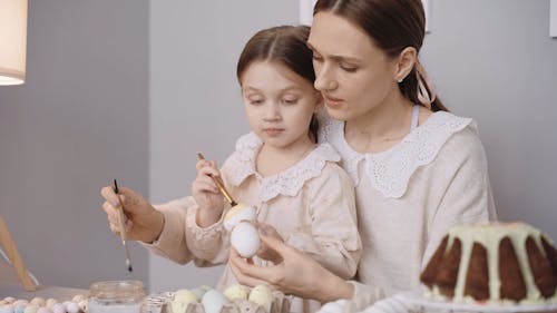 A Mother Painting Easter Eggs with Her Daughter