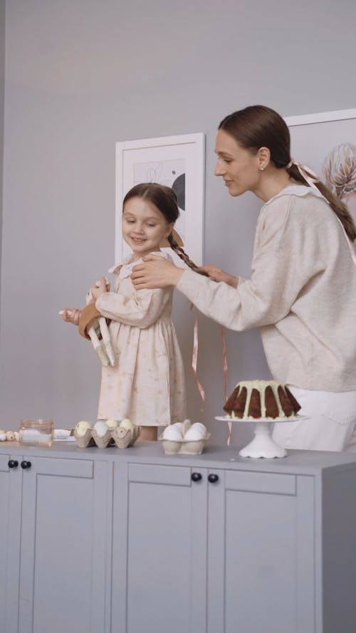 A Mother Tying Her Daughter's Hair with a Ribbon