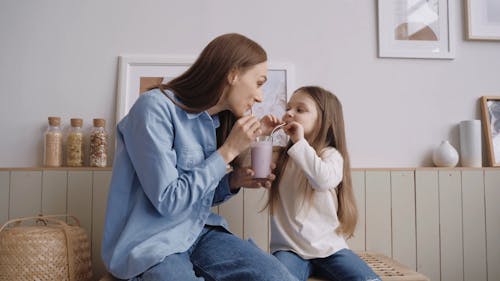 Mother and Daughter Sharing a Beverage