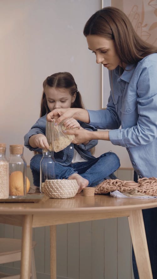 Mother and Daughter Putting Bow Tie Pasta on a Glass Container