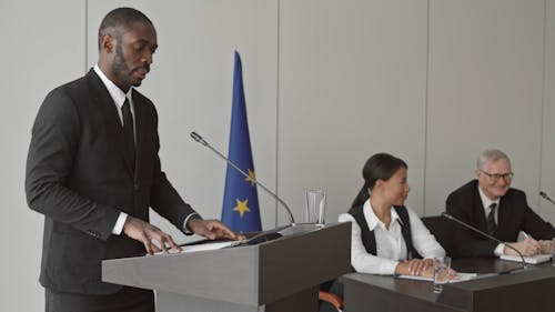 Male Standing in Podium Giving a Speech