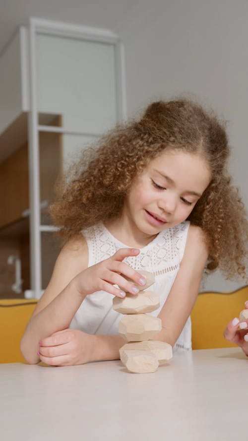 Kids Balancing Wooden Rocks with Woman