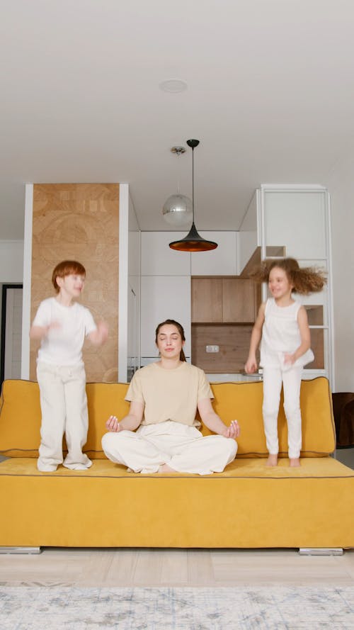 Kids Jumping While Mother Doing Meditation Yoga