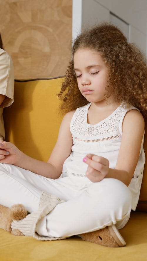 A Little Girl Meditating at the Sofa