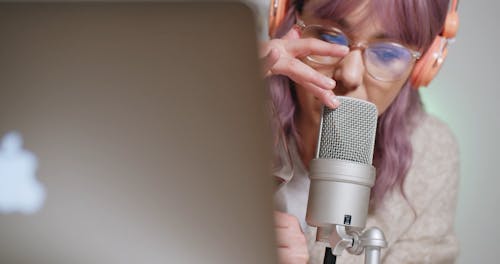 A Woman Talking on a Microphone While Holding a Wine Glass