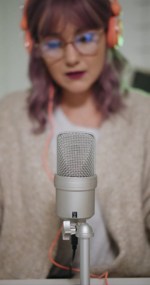 Woman Wearing Eyeglasses Touching a Microphone