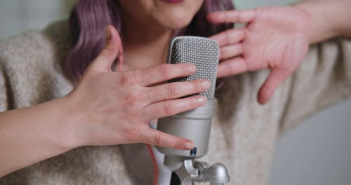 A Woman Tapping a Microphone