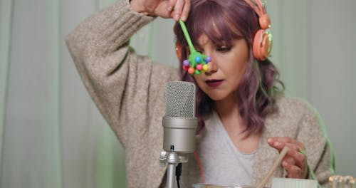 A Woman Creating and Recording Sounds Through a Toy