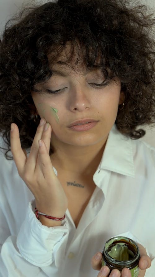 Woman Putting Cream on Her Face