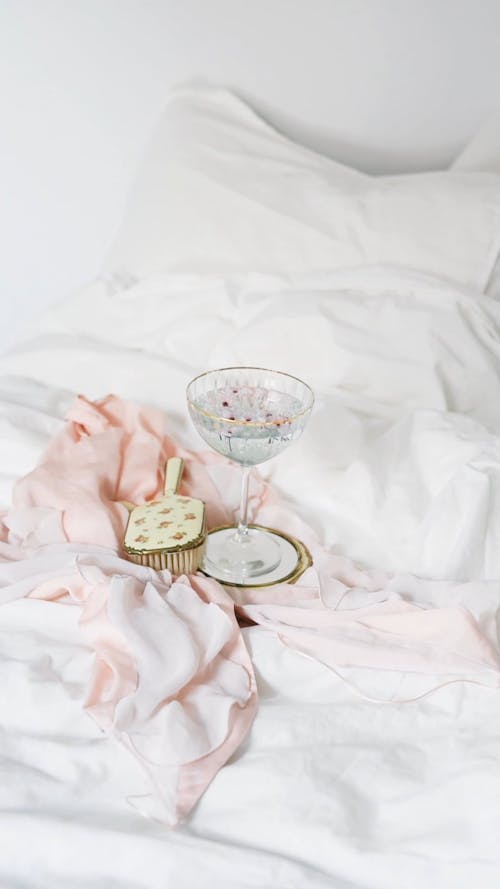 A Glass and Brush on the Bed