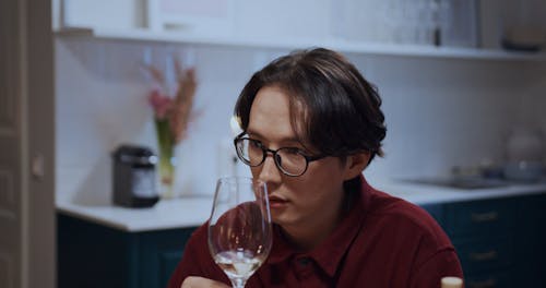 A Male Conversing while Holding a Glass of Wine