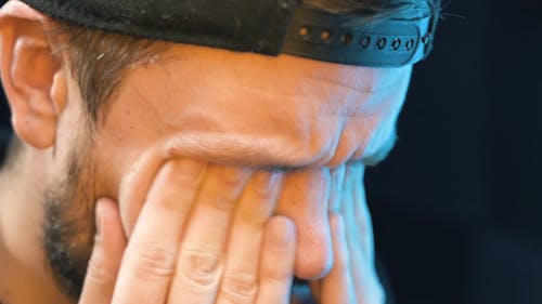 Man Working on the Computer while Rubbing his Eyes