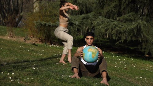 Dancing Woman While Man Hold a Globe