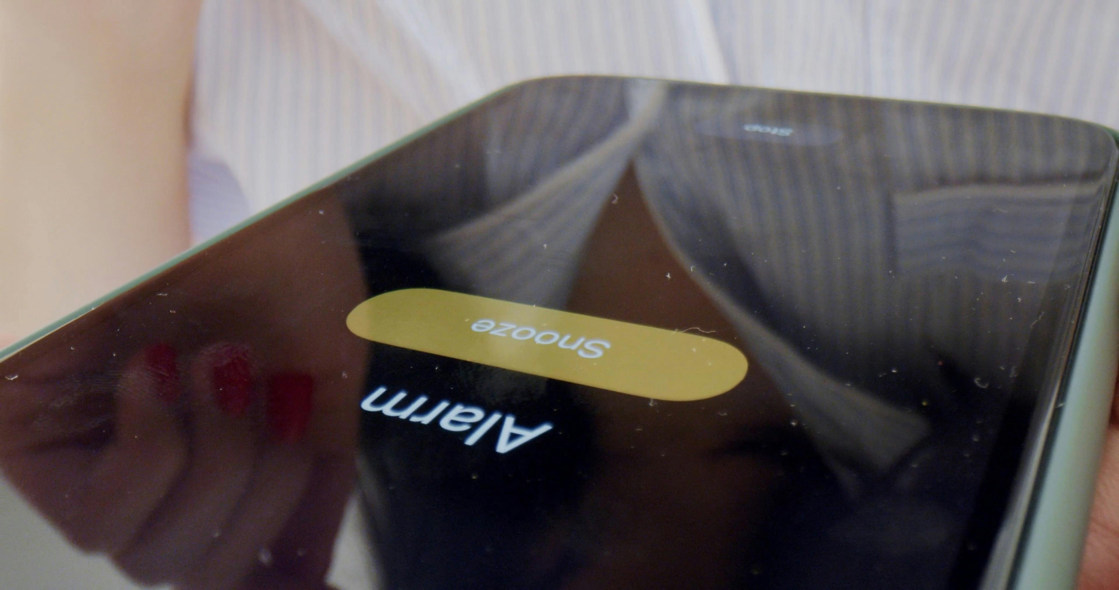 A Person Pressing Snooze on the Phone Alarm Clock Free Stock Video