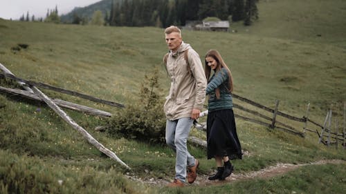 A Couple Walking Up a Trail while Holding Hands