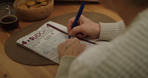 An Over the Shoulder Shot of a Person Doing a Sudoku Puzzle