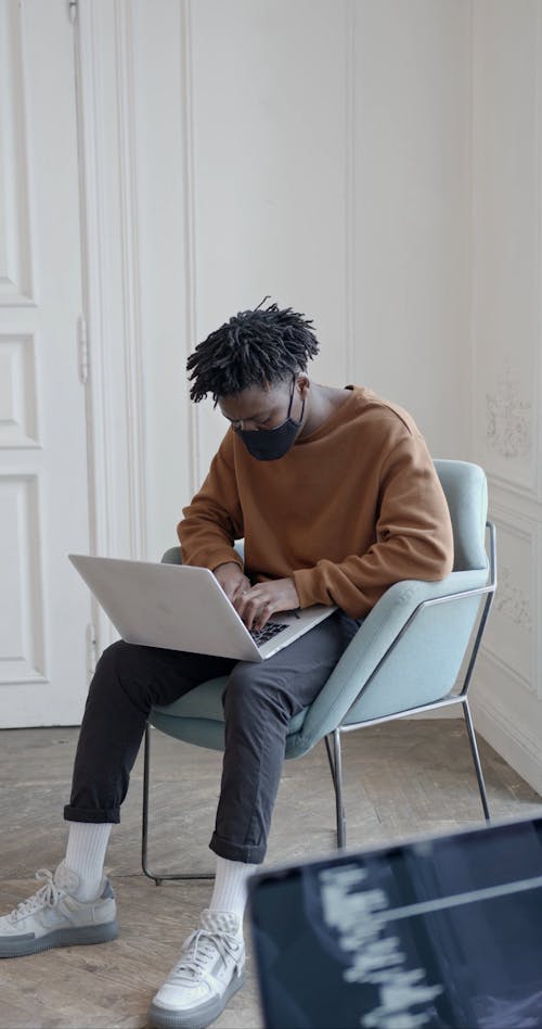 Man Sitting While Typing On Laptop
