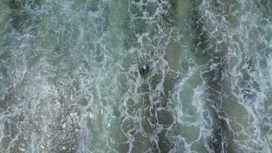 aerial shot of waves on the seashore