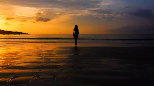 A Woman Walking Towards The Sea