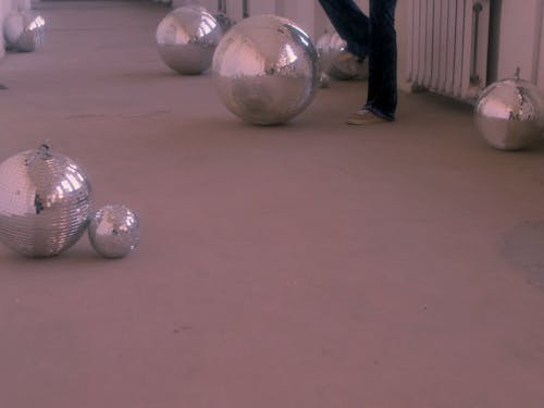 Model Posing in 70s Themed Outfit while Holding Disco Ball