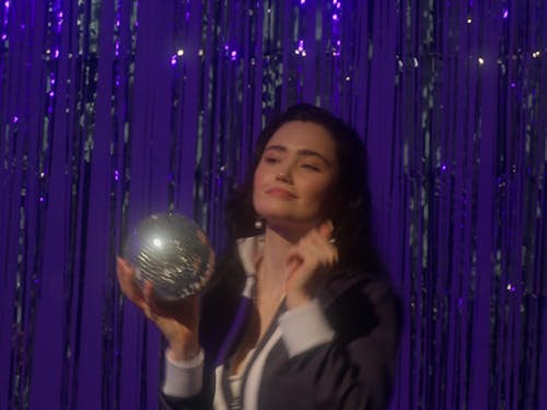 Woman Dancing While Holding Small Disco Ball