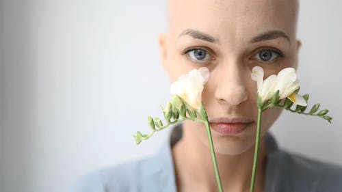 Close-Up View of a Person Holding Two White Flowers