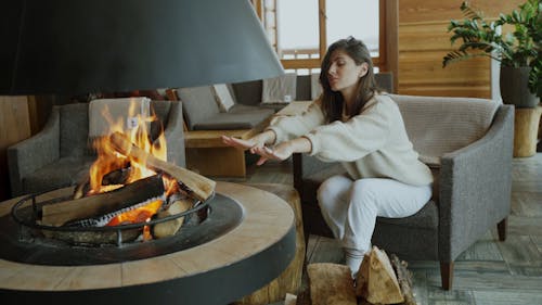 A Woman Sitting by the Fireplace