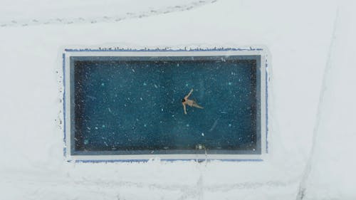 Drone Footage of a Woman Swimming in a Pool