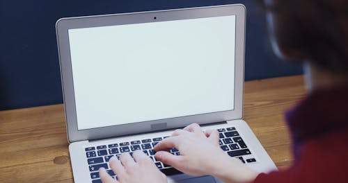 A Woman Typing On A Laptop