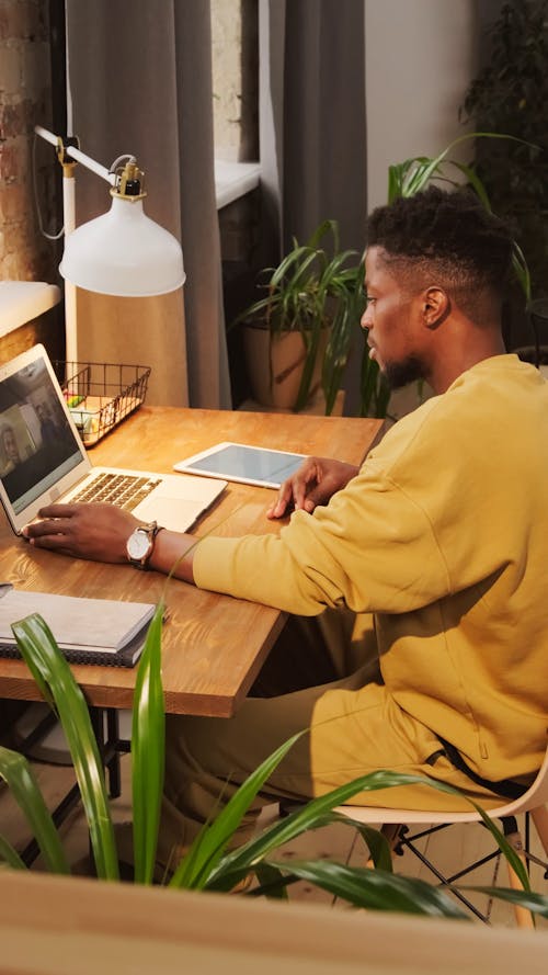 A Man Communicating Via Video Call Using A Laptop